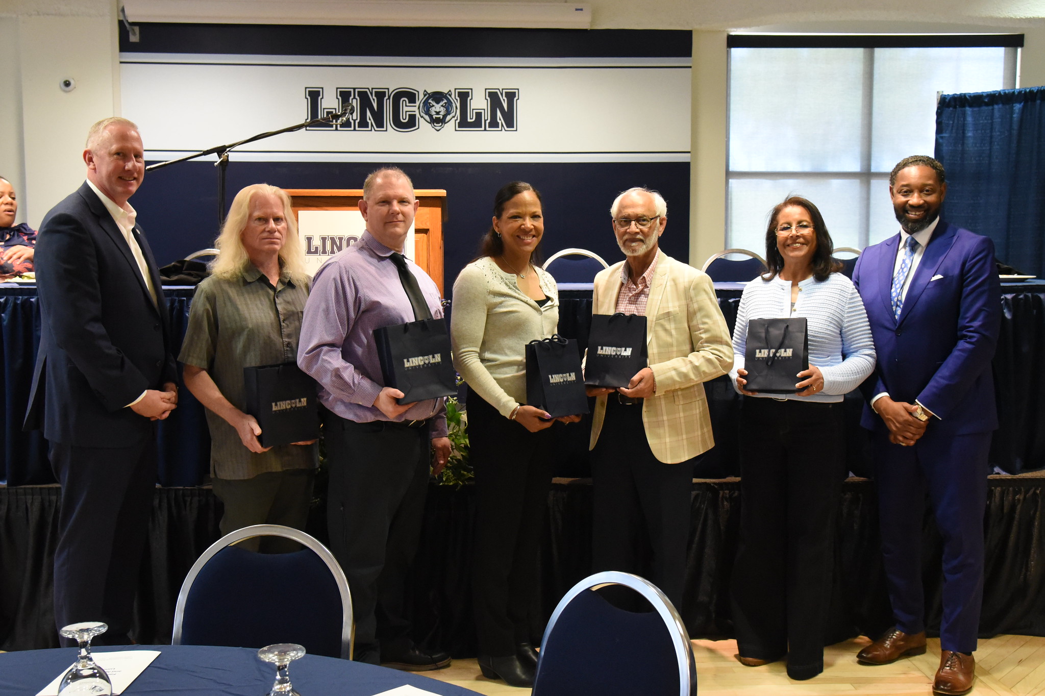 Lincoln University of Missouri faculty stand in a line with their awards during the Faculty Awards Luncheon. 