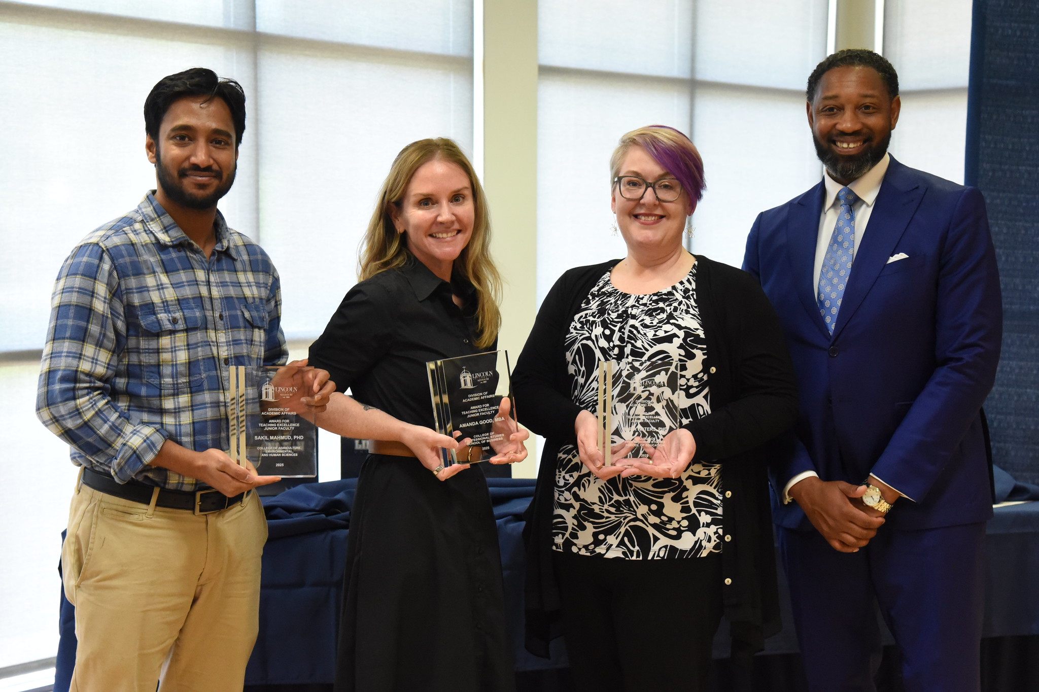 Lincoln University faculty awarded for the Junior Faculty Teaching Award stand in a line with their awards. 