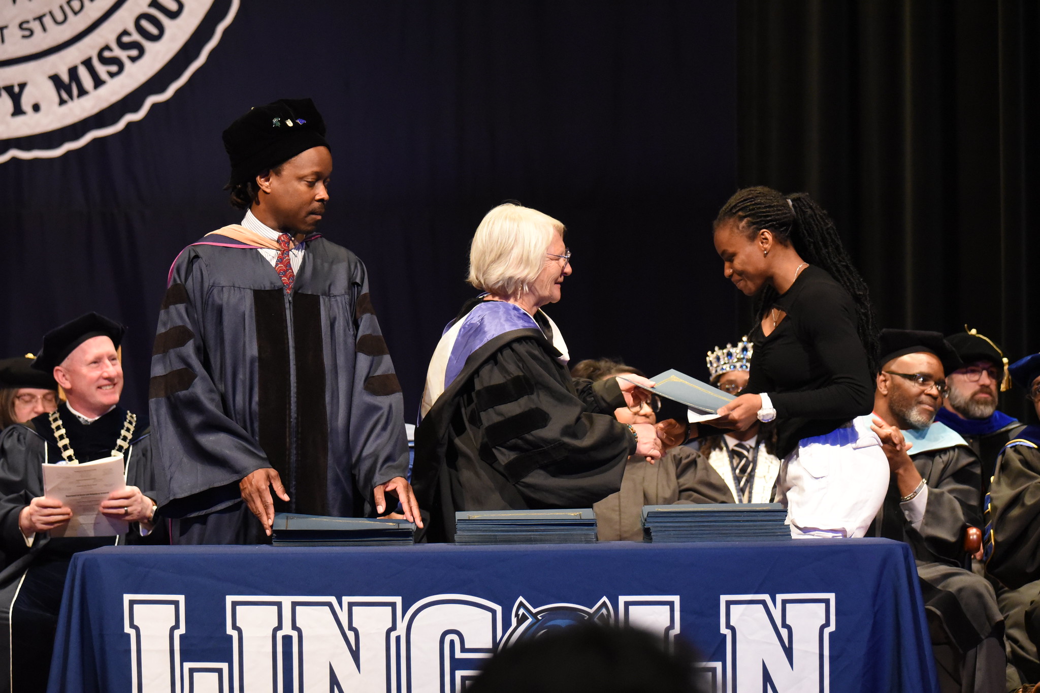 A young Lincoln University of Missouri student shakes hands with her professor as she walks across the stage at the 2025 Honors Convocation.
