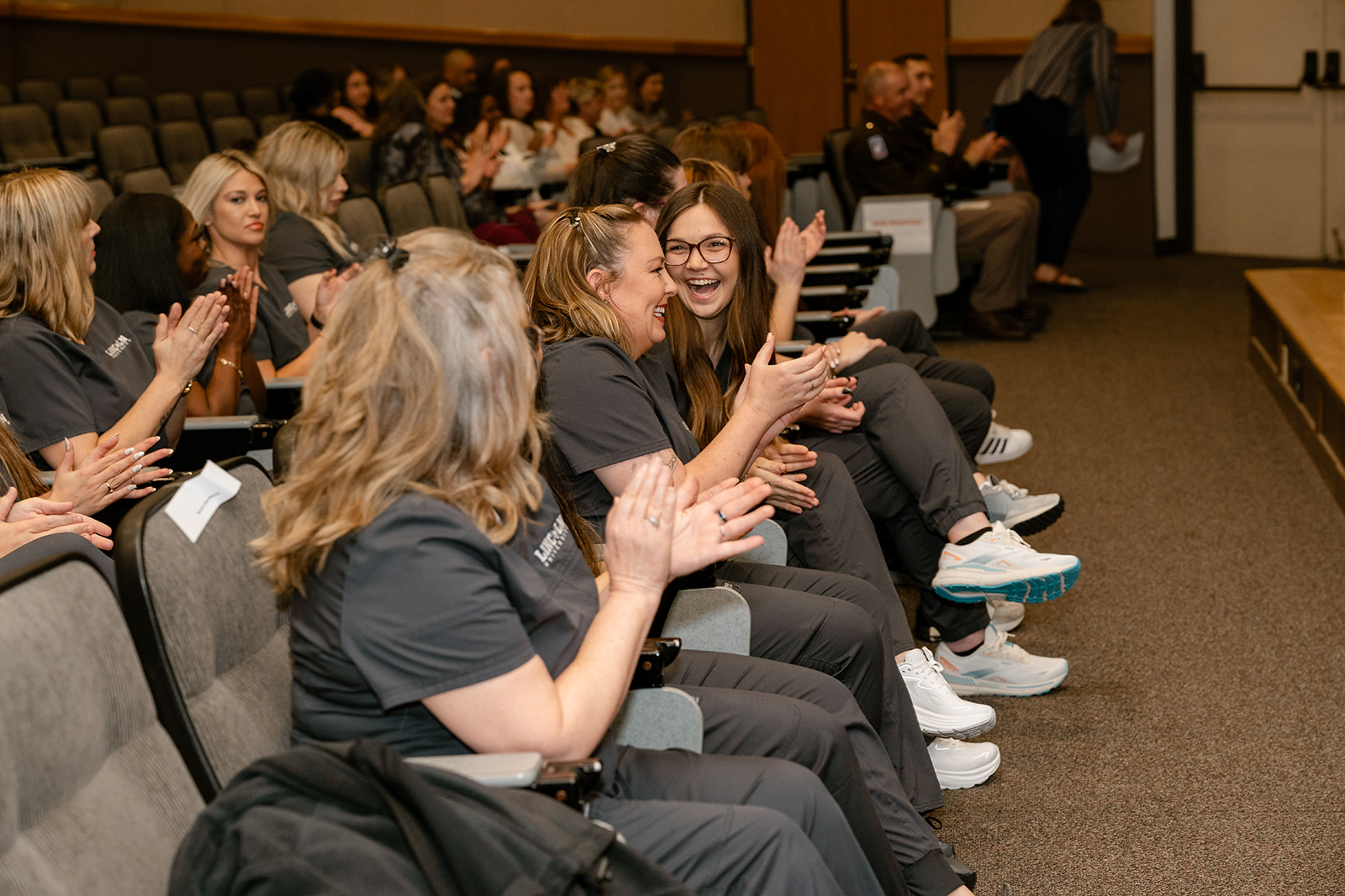 Lincoln University of Missouri Fort Leonard graduating nursing students sit in theater chairs, laughing and smiling.