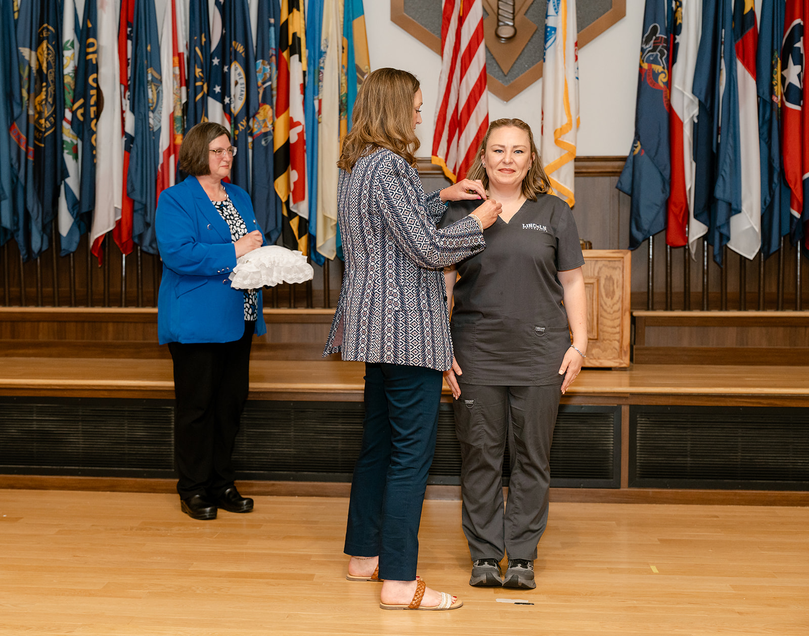 A Fort Leonard Wood nursing student recieves a pin on stage by Megan Titus at the pinning ceremony.