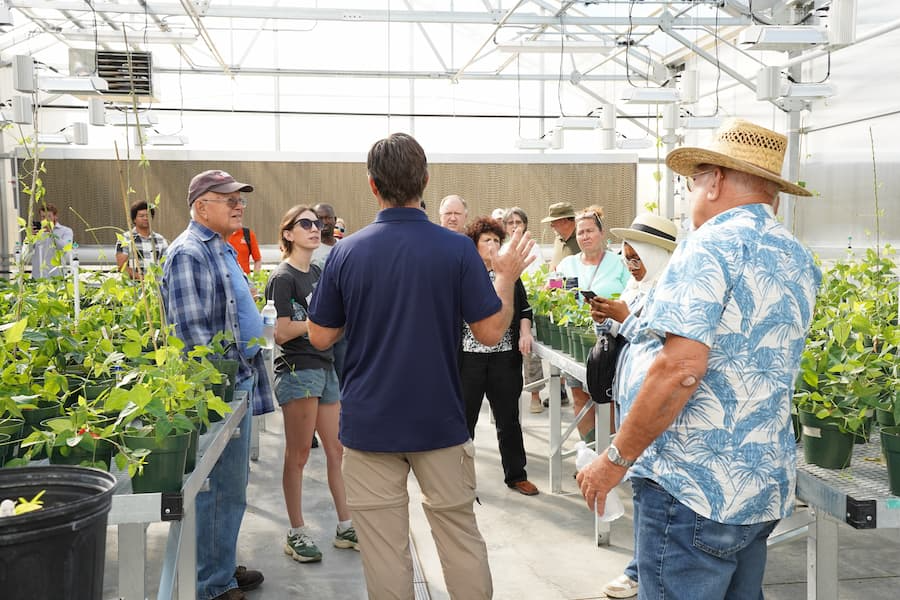 Attendees stop at a greenhouse to learn about production techniques and controlled growing environments.