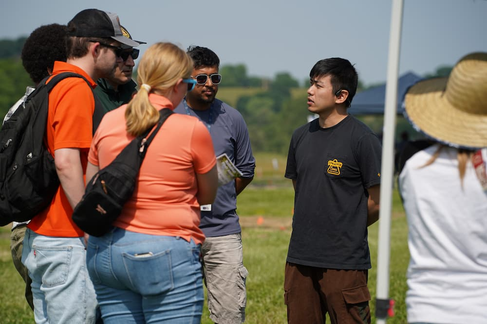 Graduate students explain how AI is used in pest control and answer attendee questions.
