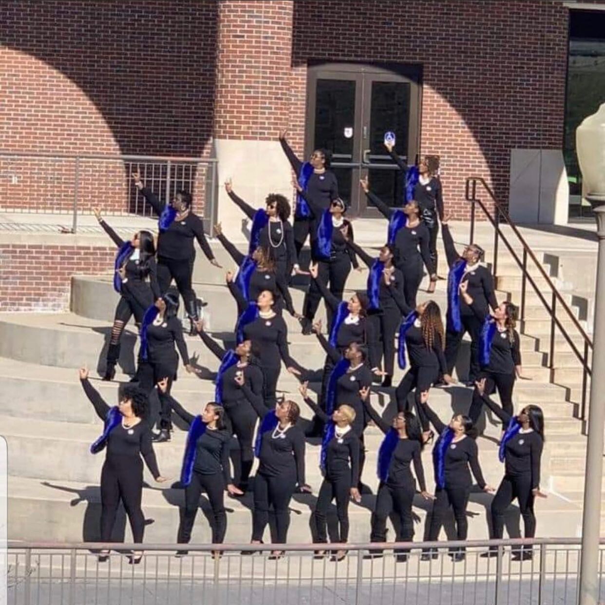 Lincoln University of Missouri Zeta sorority members stand in rows on outdoor stairsteps while posing for a photograph.