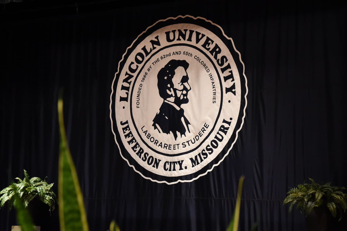 The Lincoln University of Missouri logo is seen on the stage next to a blue curtain.