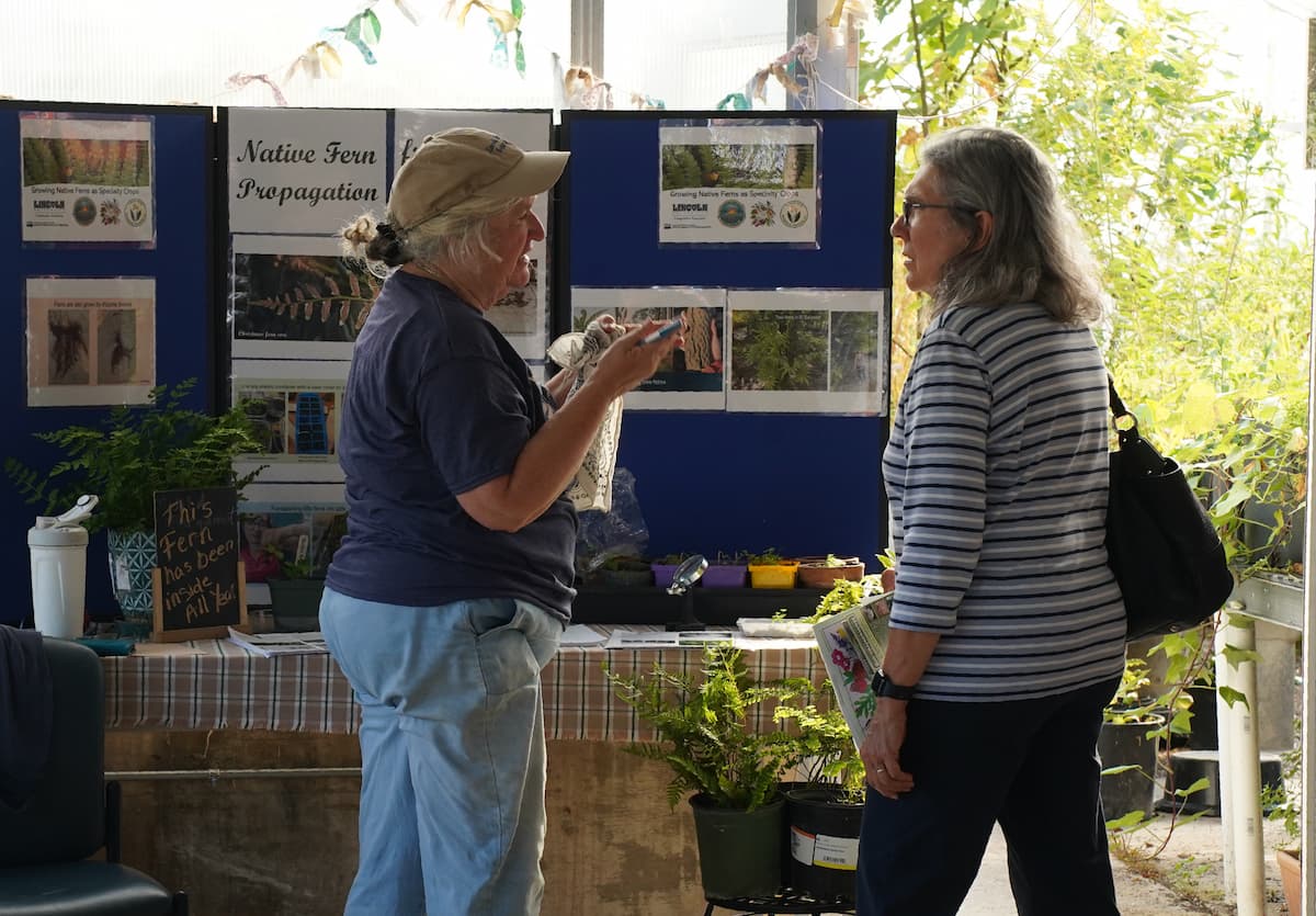 Sue Bartelette (left) of Lincoln University’s Specialty Crops and Native Plants Program speaks with a visitor about fern propagation.