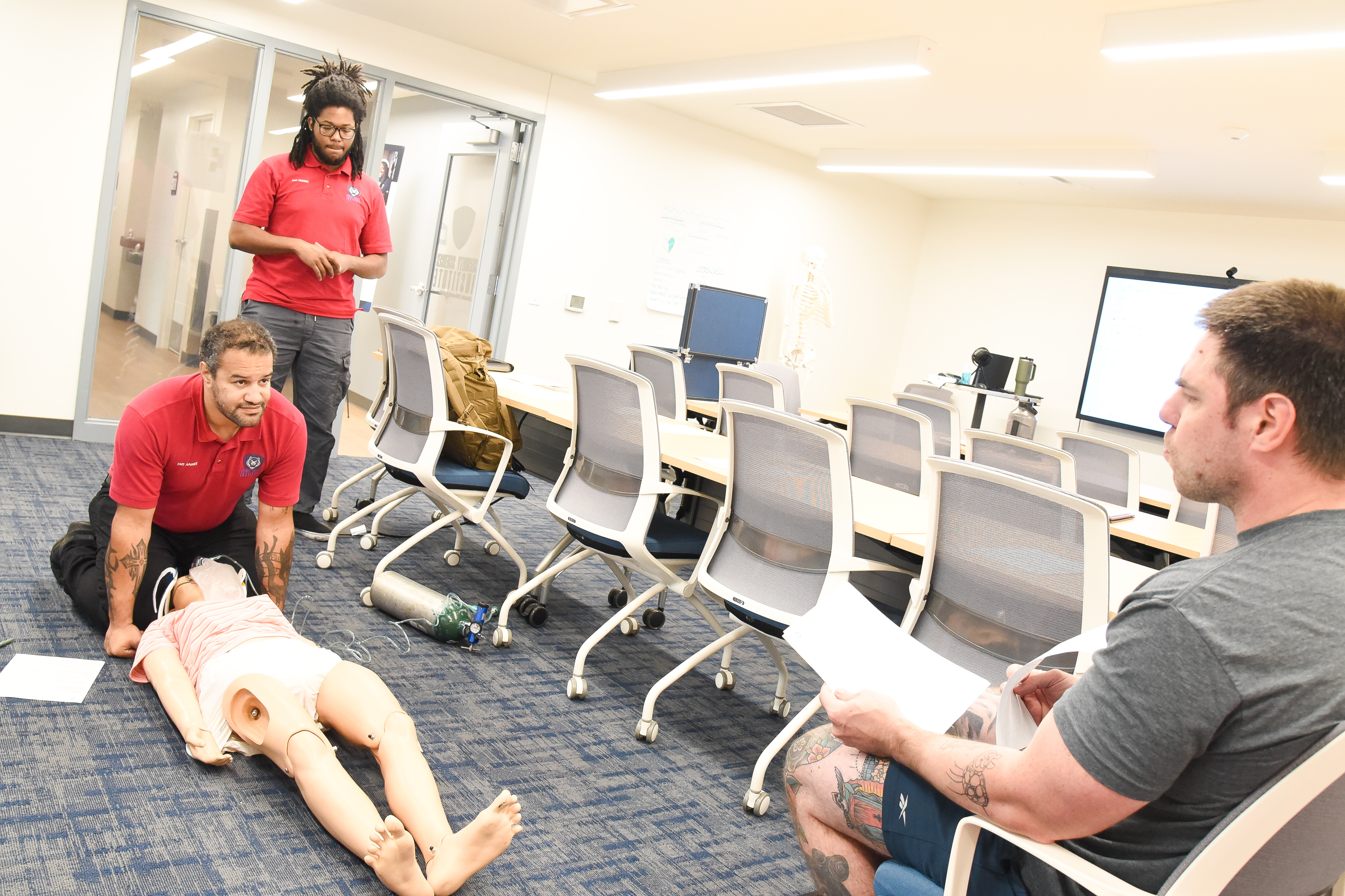 Image of an EMT student learning to care for a patient using a practice dummy