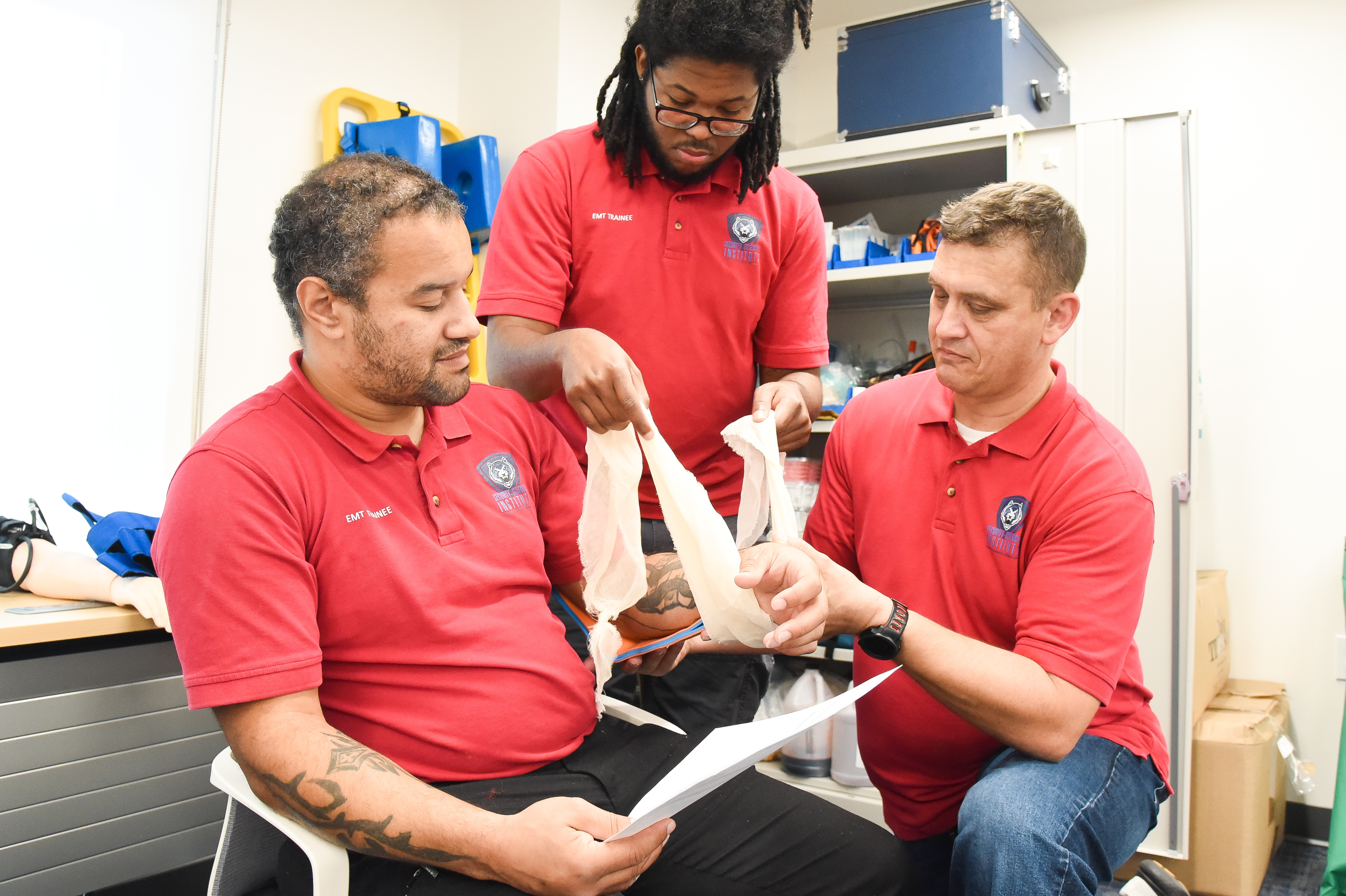 Photo of students learning to draw blood during the LUEA EMT certificate program course
