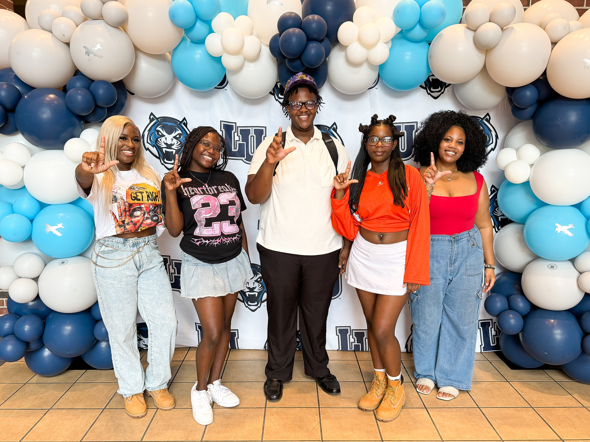 smiling students with L