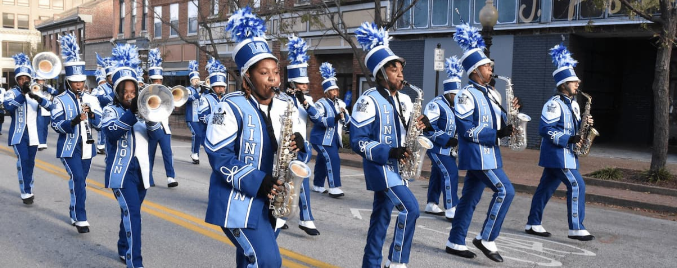 Members of Lincoln University of Missouri’s marching band perform while marching in formation along a downtown Jefferson City street.