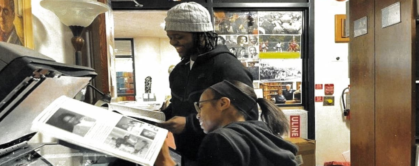 Two student workers read through materials in the Lincoln University Archives.