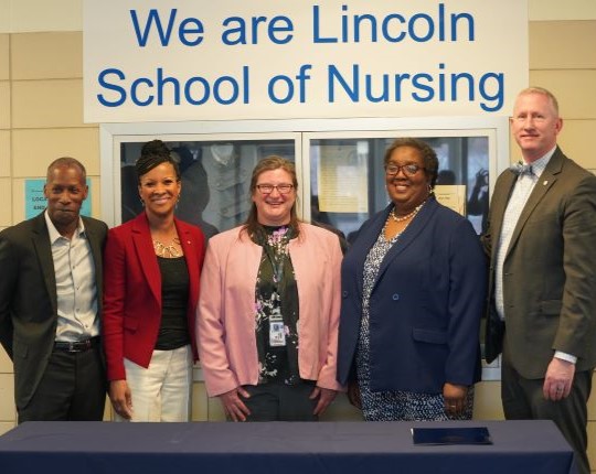 depiction of The Mid-Missouri Black Nurses Association and Lincoln University signed an agreement to support future nursing students through the Helen L. Monroe Mentorship Program. Pictured left to right: grandson of Helen L. Monroe, Michael Oliver; granddaughter of Helen L. Monroe, Jackie Henry; Lincoln University School of Nursing Department Head Dr. Jennifer McCord, Mid-Missouri Black Nurses Association President Leana Mahaney, and Lincoln University President Dr. John B. Moseley.