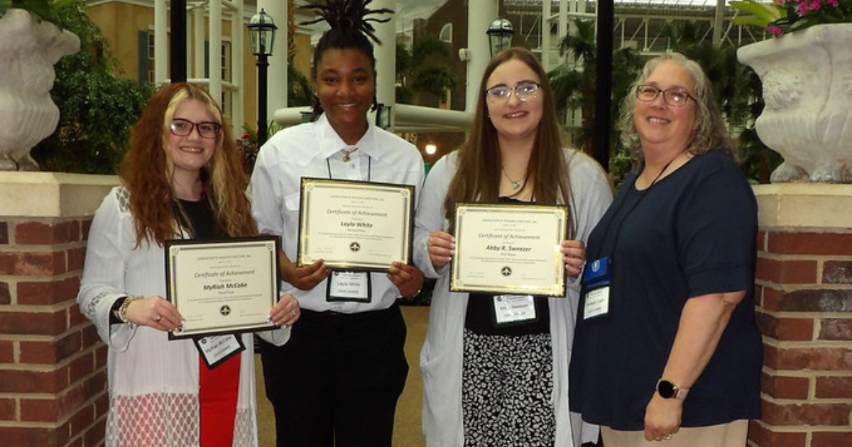 (Left) MyRiah McCabe, Layla White, Abby Sweezer stand with their advisor Kim Cash (right) after the awards ceremony. 