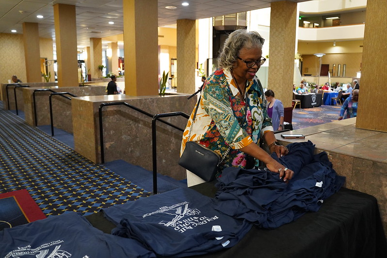 PJCCHA’s Glenda Meachum-Cain arranges T-shirts for participants at the 2024 Missouri Institute on Minority Aging (MIMA) Conference.