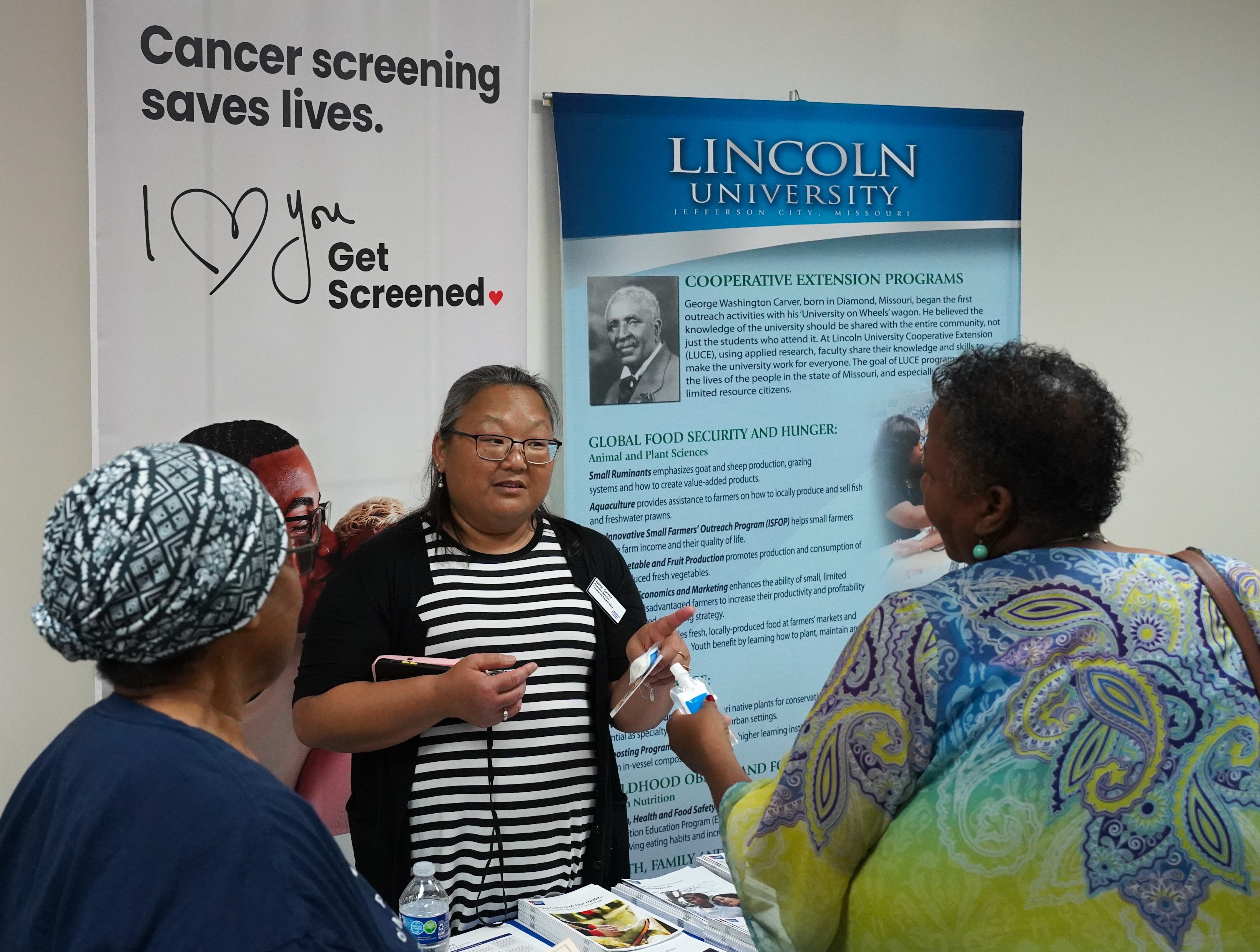 An exhibitor shares cancer prevention information with attendees at the Paula J. Carter Center on Health and Aging’s community health event.