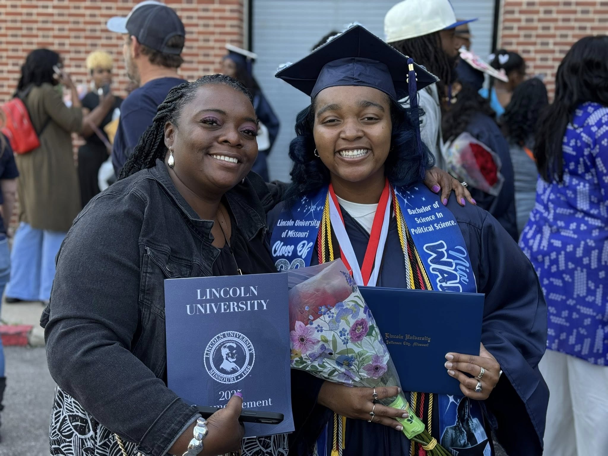 Lincoln University of Missouri graduate Nia Walker poses with a family member outside with her diploma after the graduation ceremony.