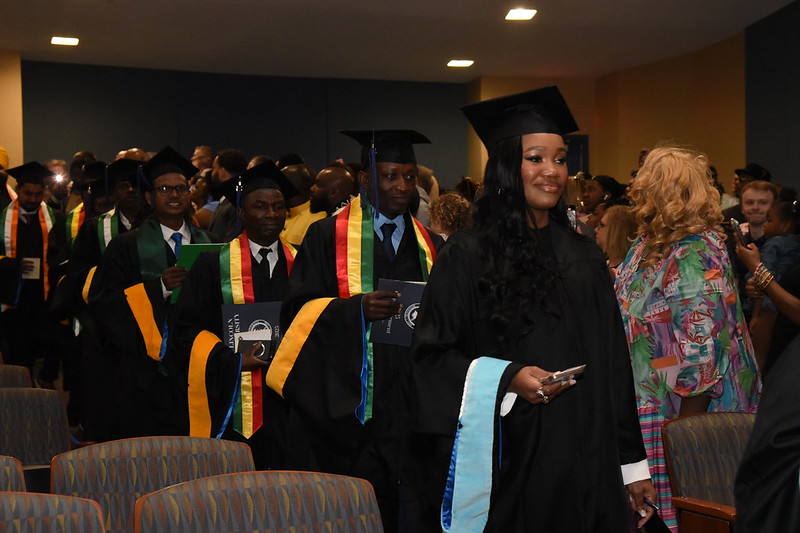 Lincoln University of Missouri graduates walk into the auditorium in their graduation regalia.