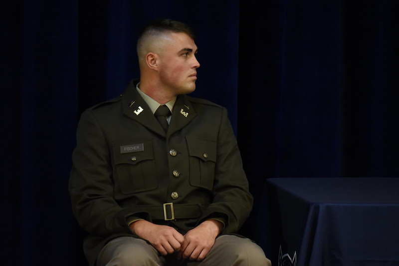 Lincoln University of Missouri Cadet Blake Fischer sits on stage while looking to his left.