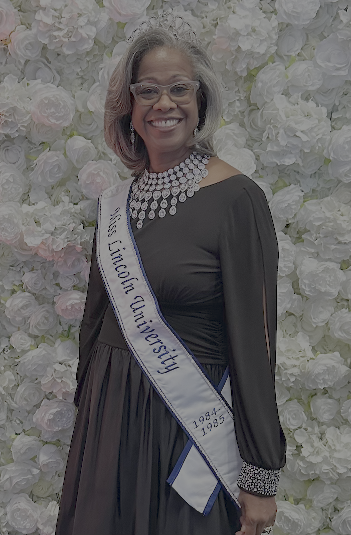 Lincoln University alumna Staci Garrett Oliver stands in a navy dress with a Miss Lincoln sash during Homecoming 2024.