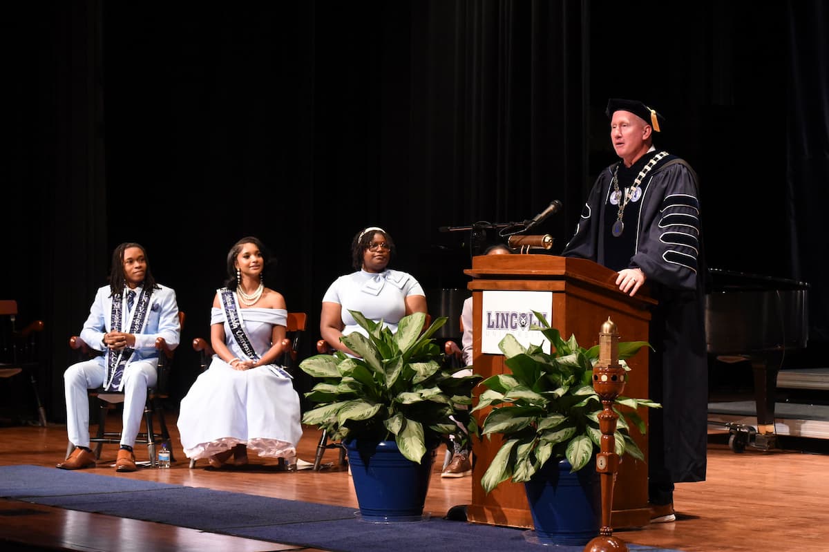 Lincoln University of Missouri President Moseley stands behind a podium on stage while addressing students.