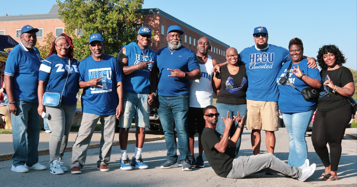 A group of Lincoln University of Missouri alumni in blue spirit wear pose for a photo on campus.