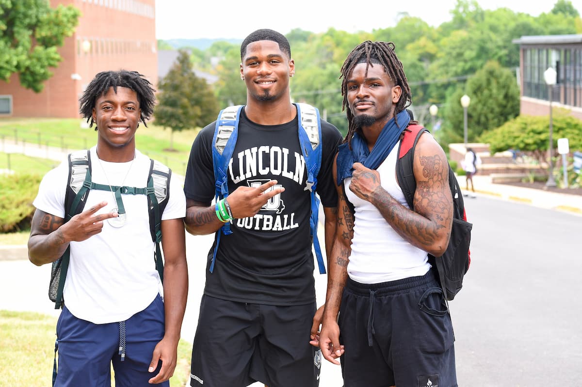 Three male Lincoln University of Missouri students pose for a photo while outside on campus.
