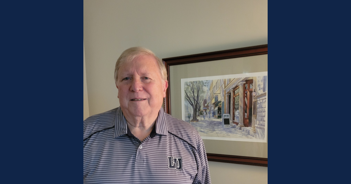 Dennis Strobel, facing forward with a painting on wall behind him