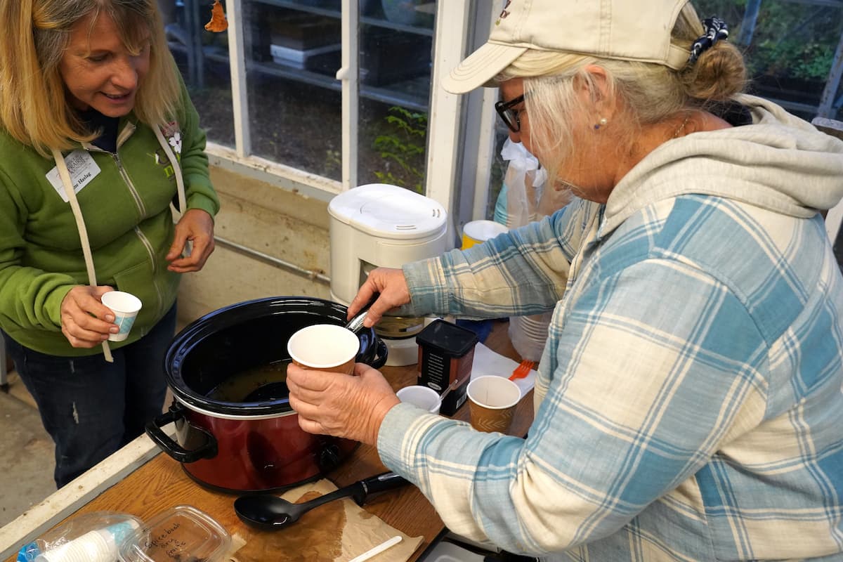Sue Bartelette (left), landscape designer with the Native and Specialty Crops Program, serves apple cider infused with spicebush to an attendee.
