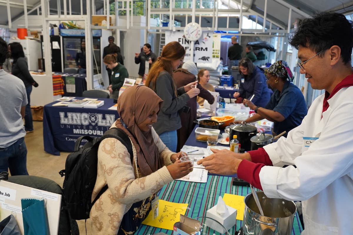 An attendee samples organic luffa soup prepared by Cooperative Research at the event.