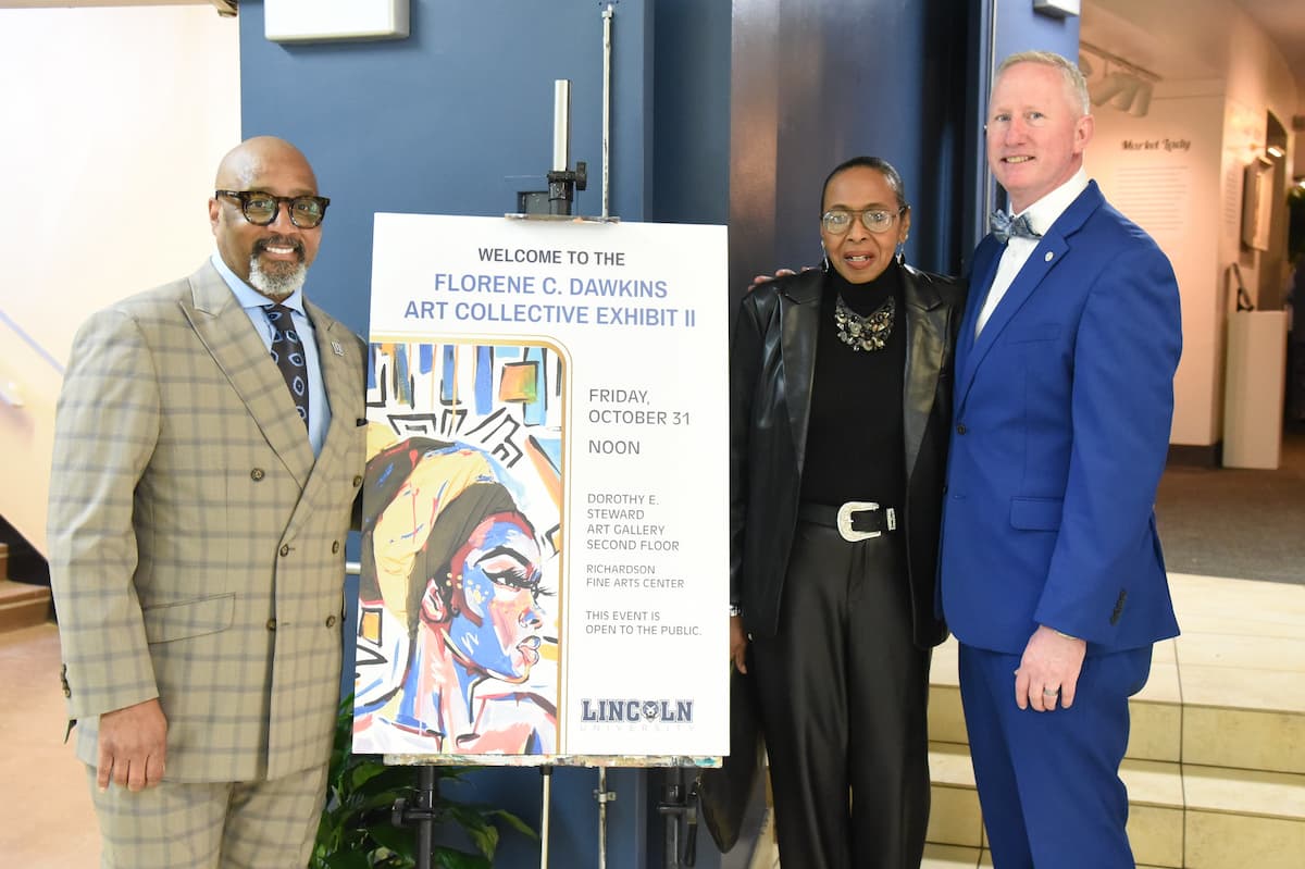 Three people stand by the entrance sign to the Florene Dawkins Art Exhibit II.
