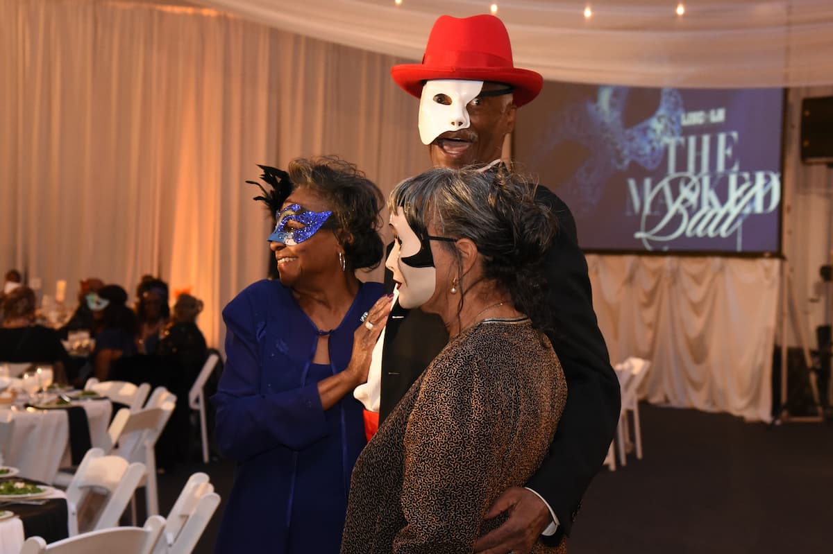 Attendees in elegant masks and evening wear enjoy the festivities at Lincoln University’s 2025 Masked Ball.