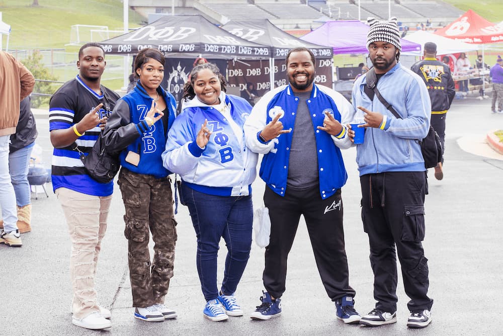 Lincoln University of Missouri alumni dressed in blue and white celebrate at the tailgate.