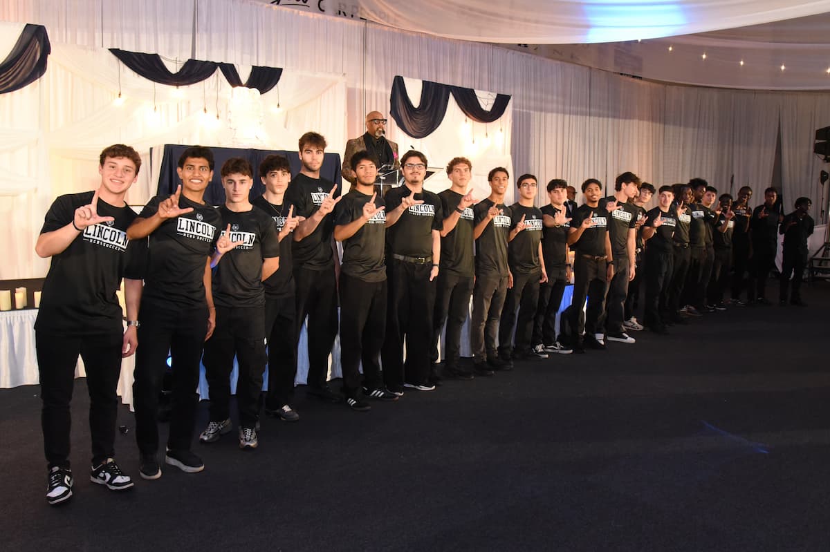 Members of the Lincoln University men’s soccer team are honored during the 2025 Masked Ball, lined up proudly in team shirts on stage.