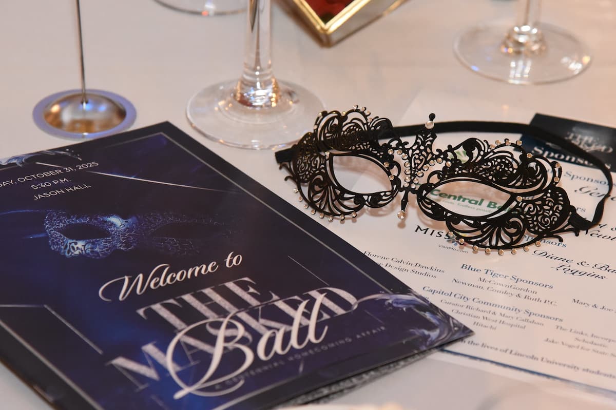 The Lincoln University of Missouri Masked Ball table is set with the program booklet and a mask.