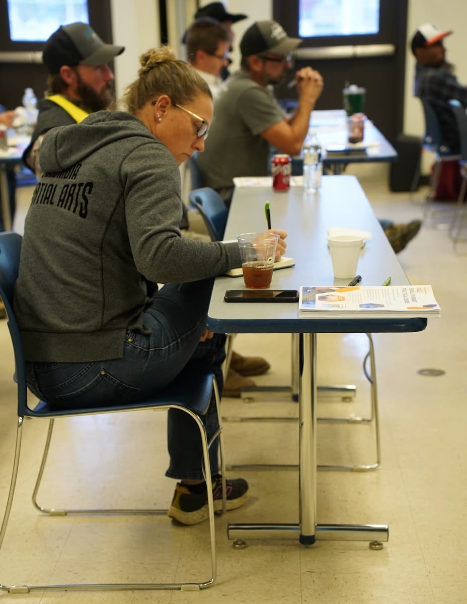 A participant focuses on learning sheep and goat management techniques and takes notes during the Small Ruminant Practical Course.