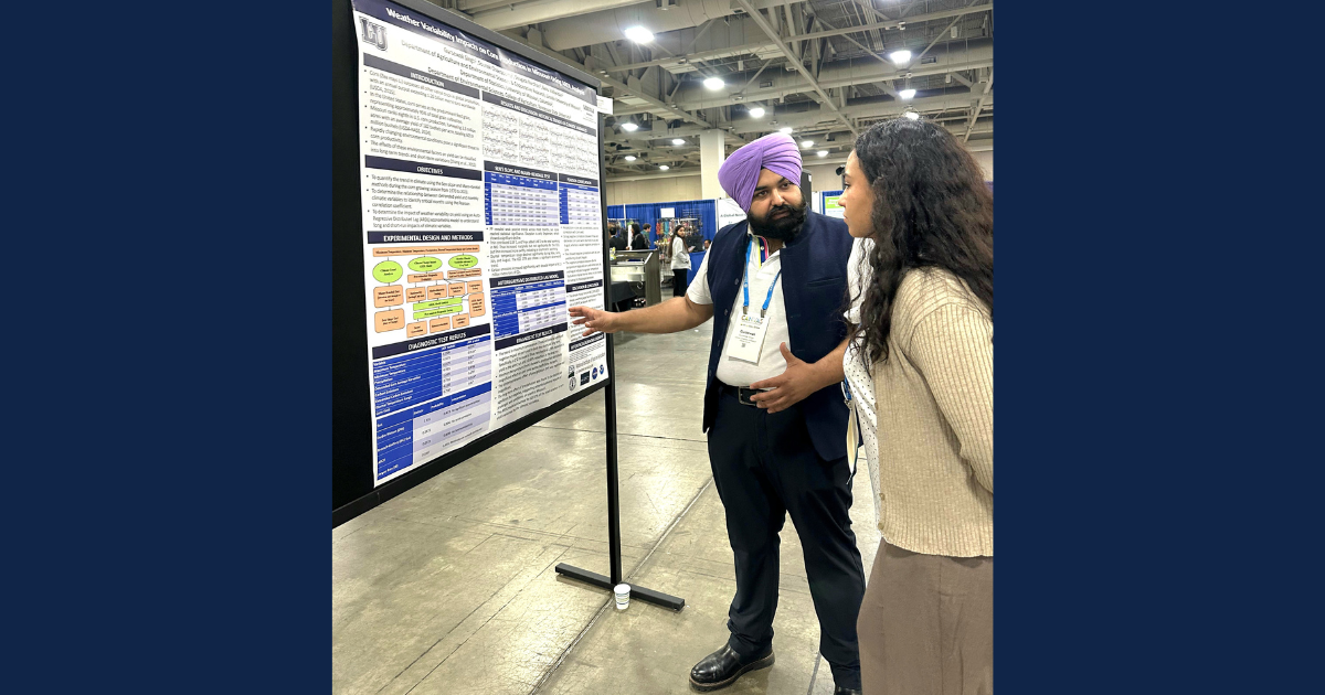 A man pointing at a poster in front of a woman.