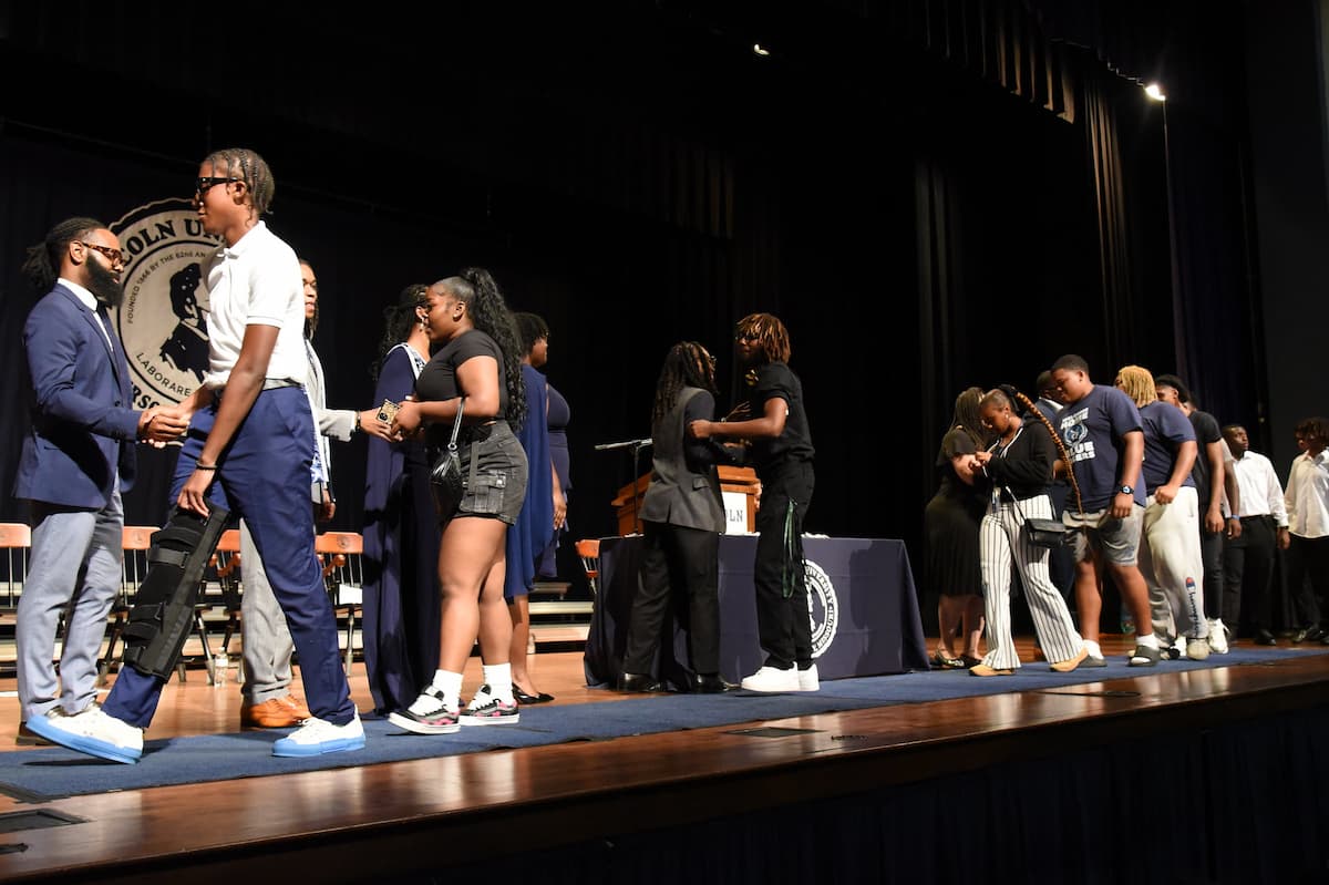 Lincoln University of Missouri students walk across the stage while shaking hands with university offiicals while at the 2025 Fall Convocation.