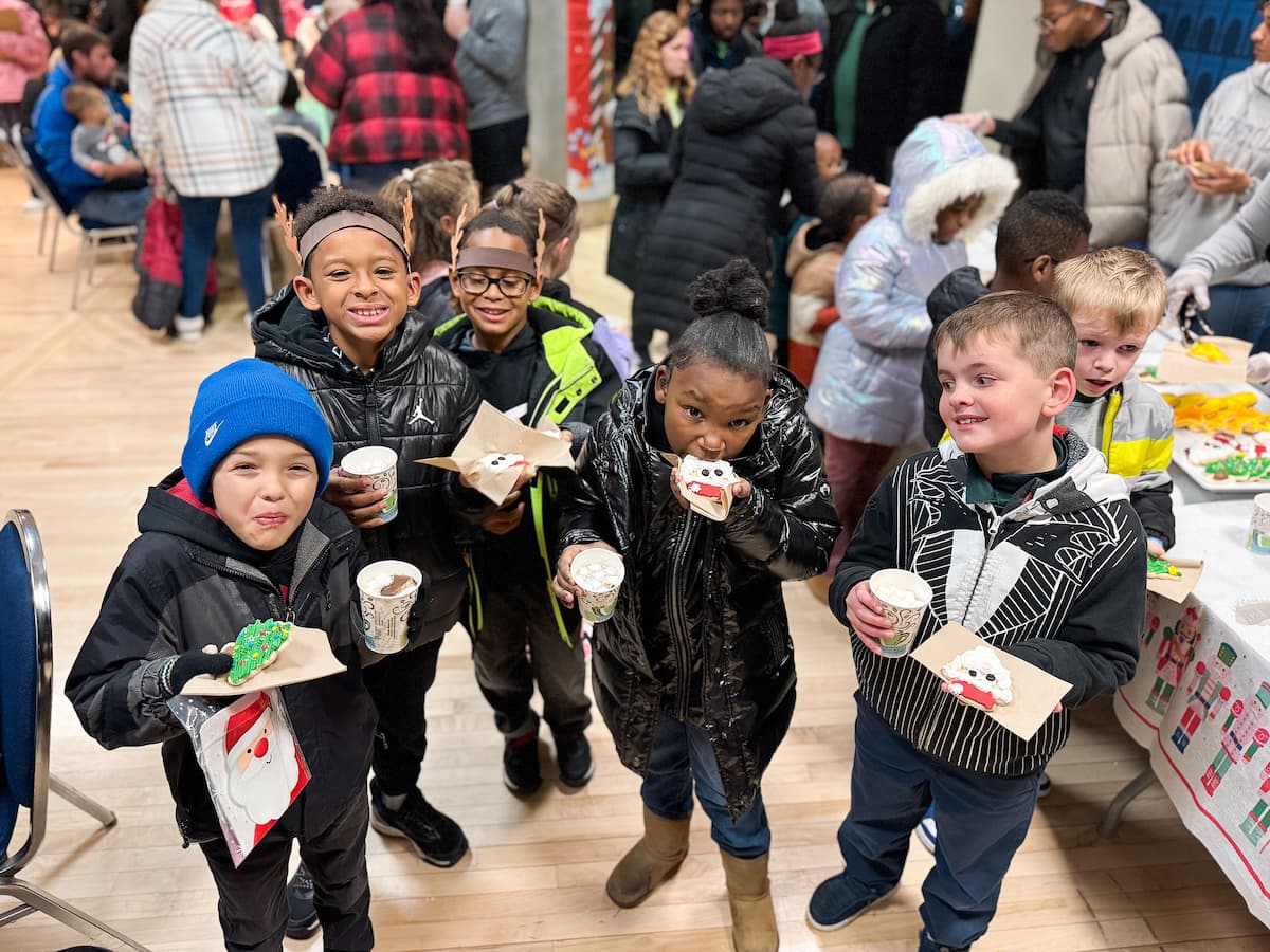 Children eat cookies and drink hot cocoa at the Holiday Extravaganza.
