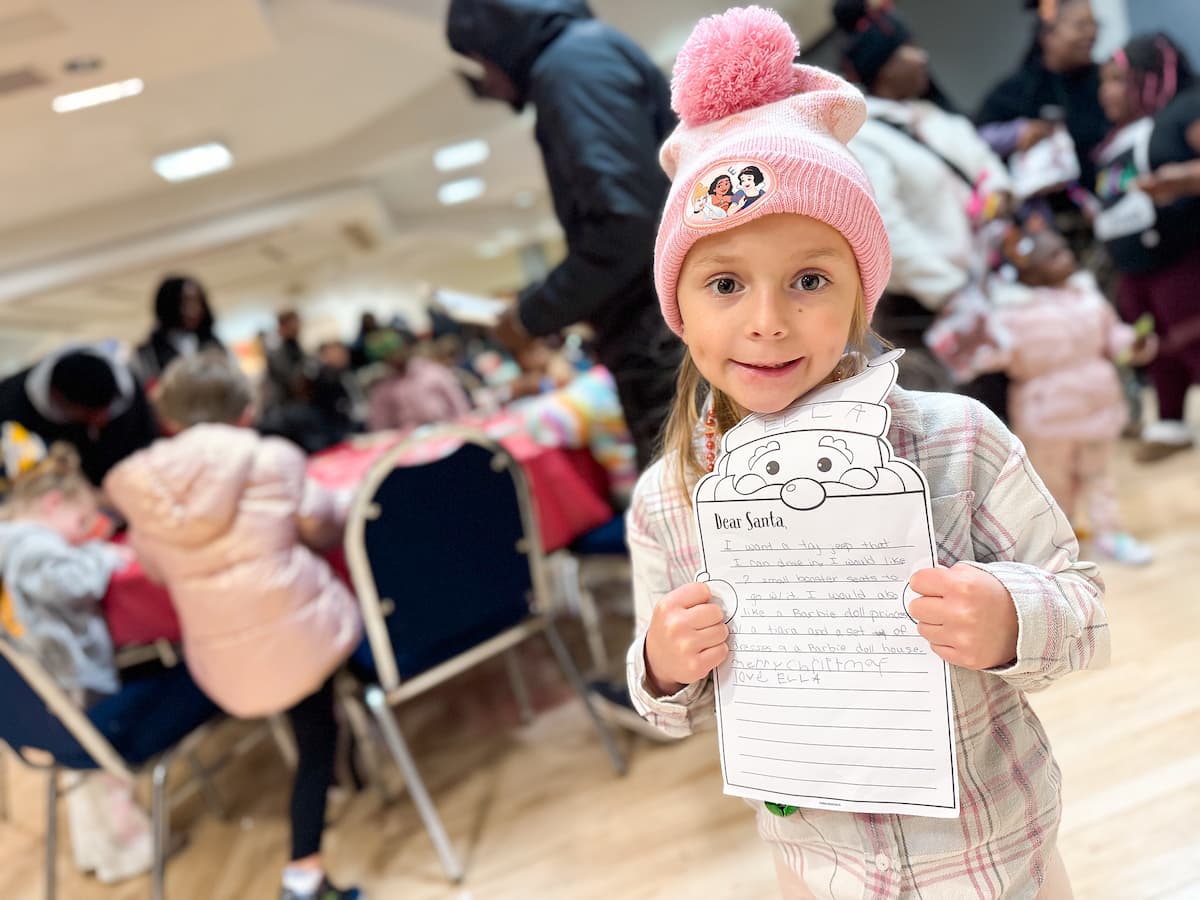 A little girl holds up a craft she made at the Holiday Extravaganza.