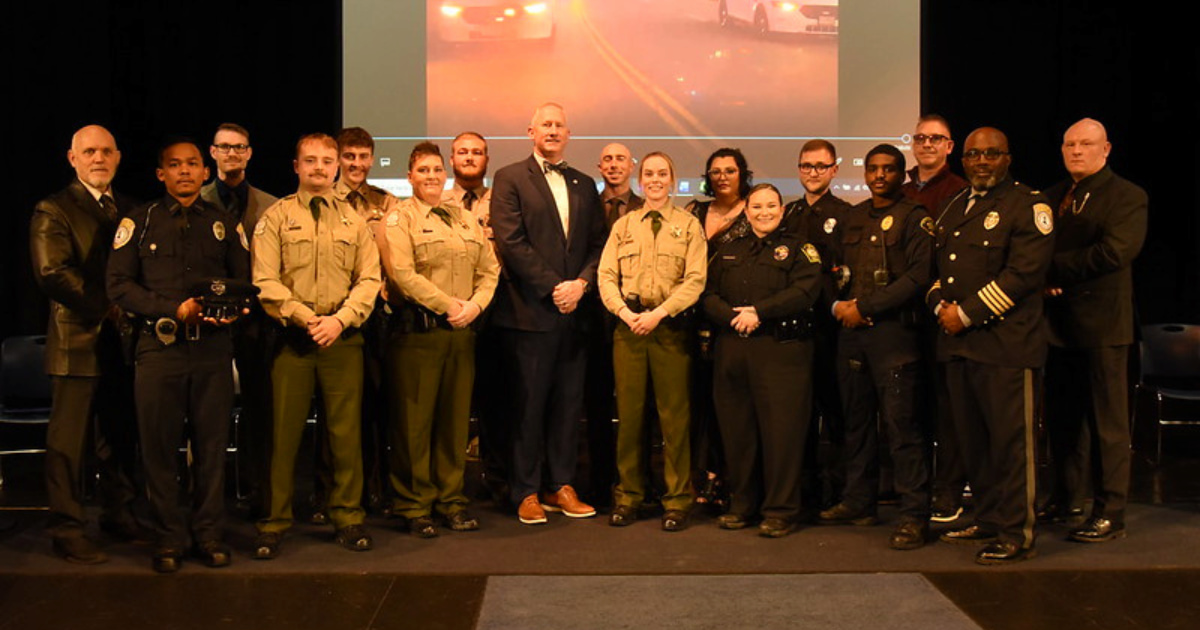 Graduates and instructors from the Lincoln University Law Enforcement Training Academy stand on stage for a group photo during the Fall 2025 graduation ceremony.