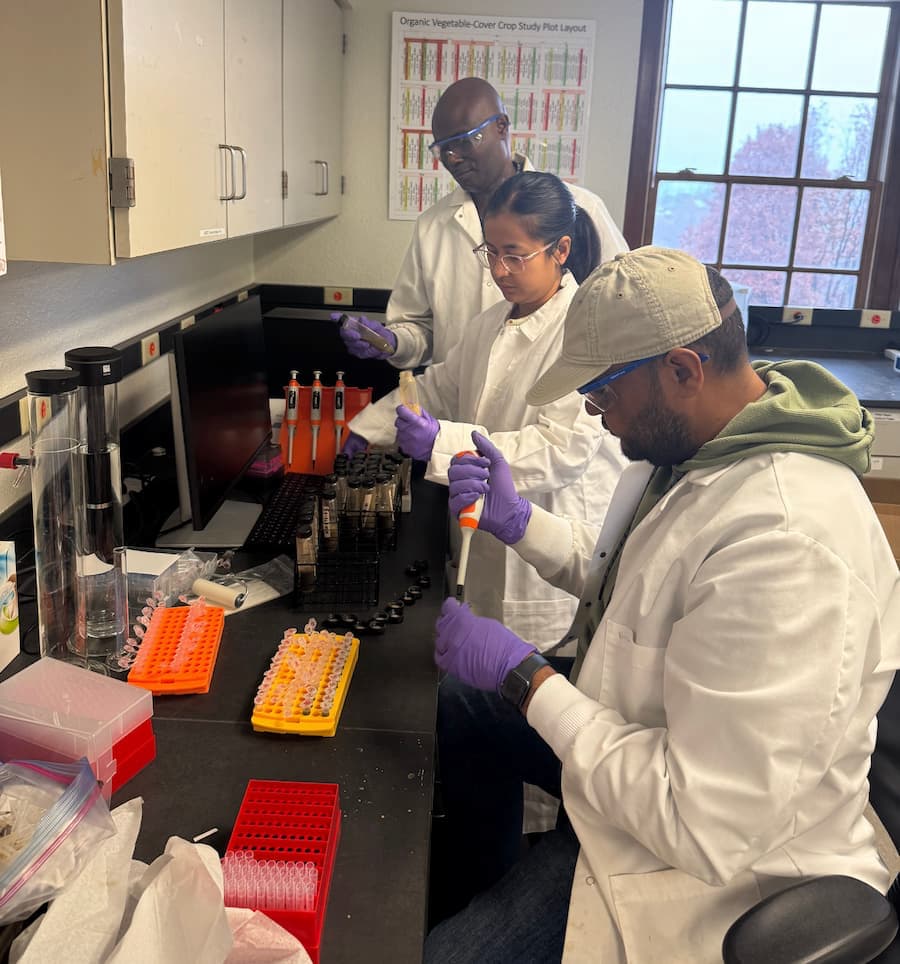 Three people in lab coats in a laboratory.