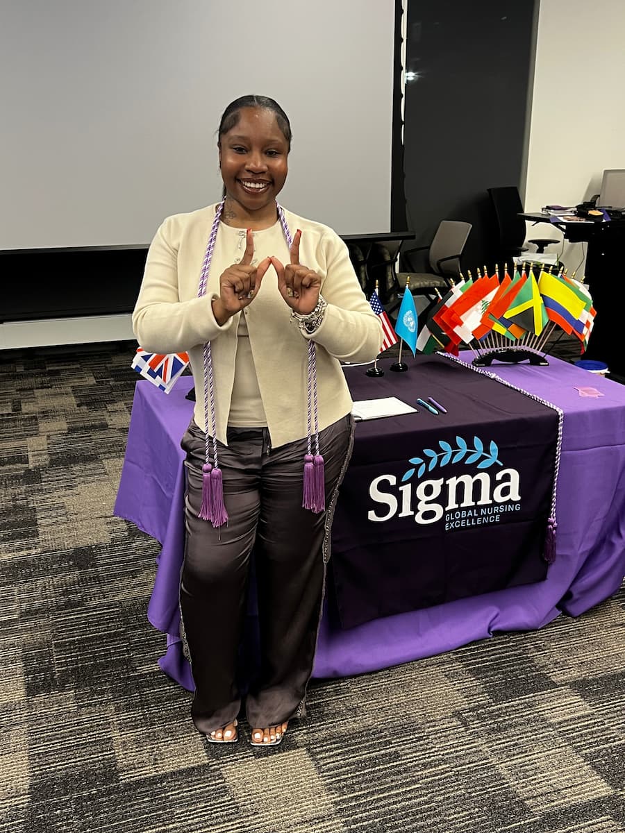 Lincoln University of Missouri nursing student Aries Atkins smiles and poses for a photo while making a "W" with her hands.