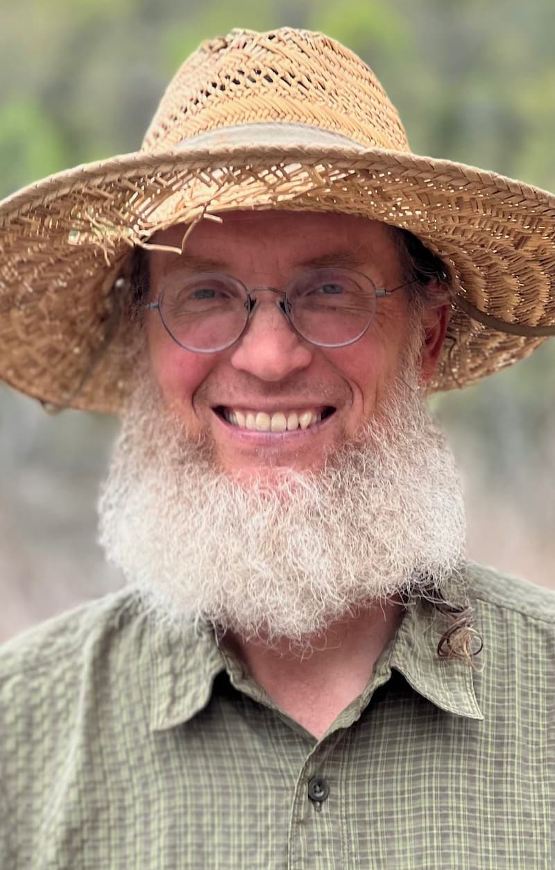 Headshot image of Curtis Millsap with a straw hat and a green button up shirt.