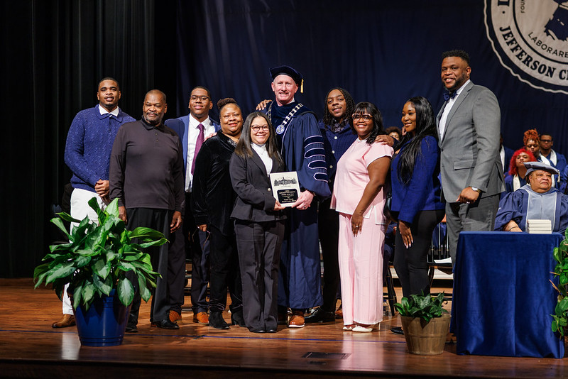 The Cooper family poses on stage with President John Moseley after being recognized during Lincoln University’s Founders’ Day Convocation.