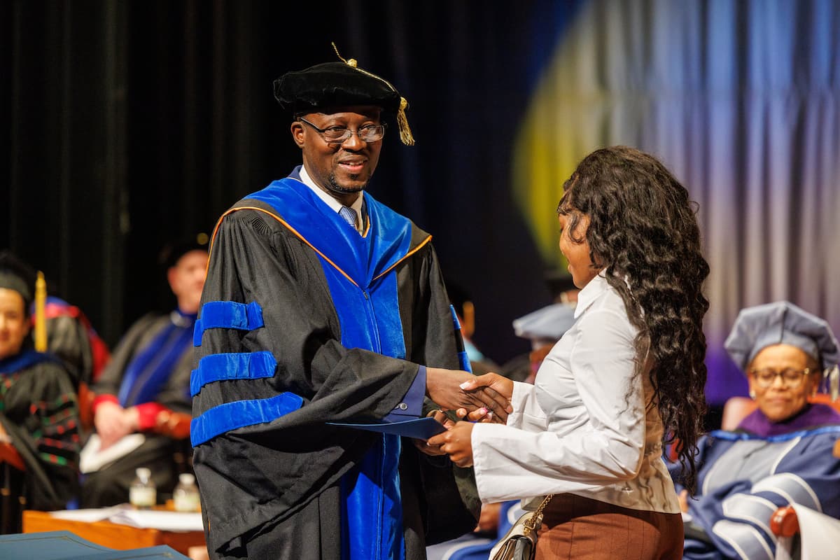 A Lincoln professor shakes the hand of a top student at the Honors Convocation.