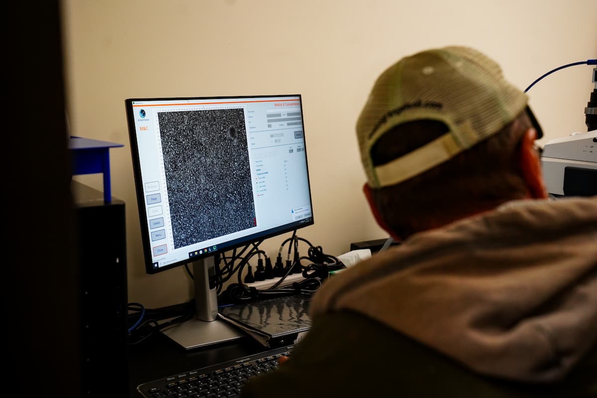 A computer displaying a detailed black and white microscopic image with data and control panels on the screen. 