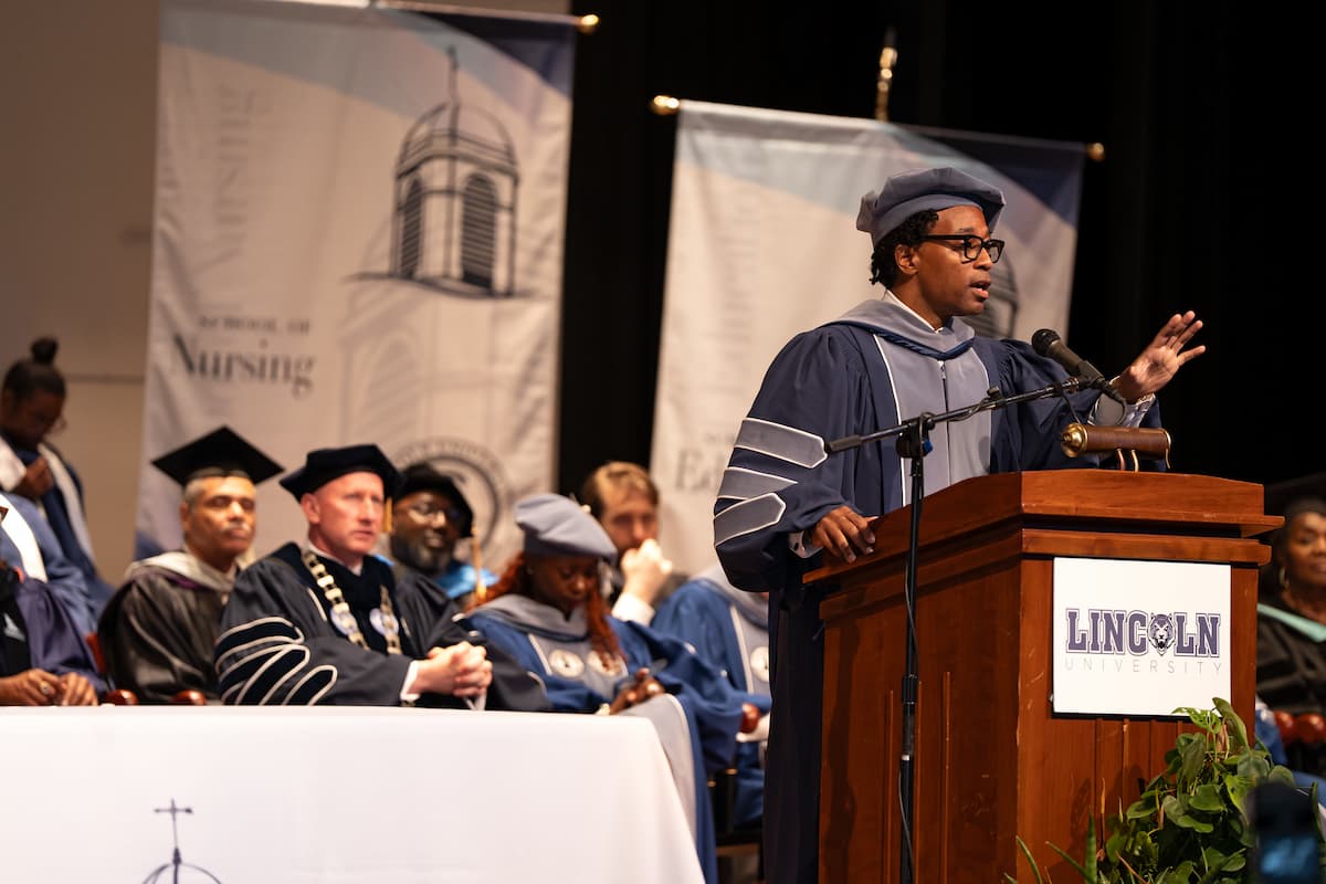Rep. Bell stands at the podium while giving a speech at commencement.