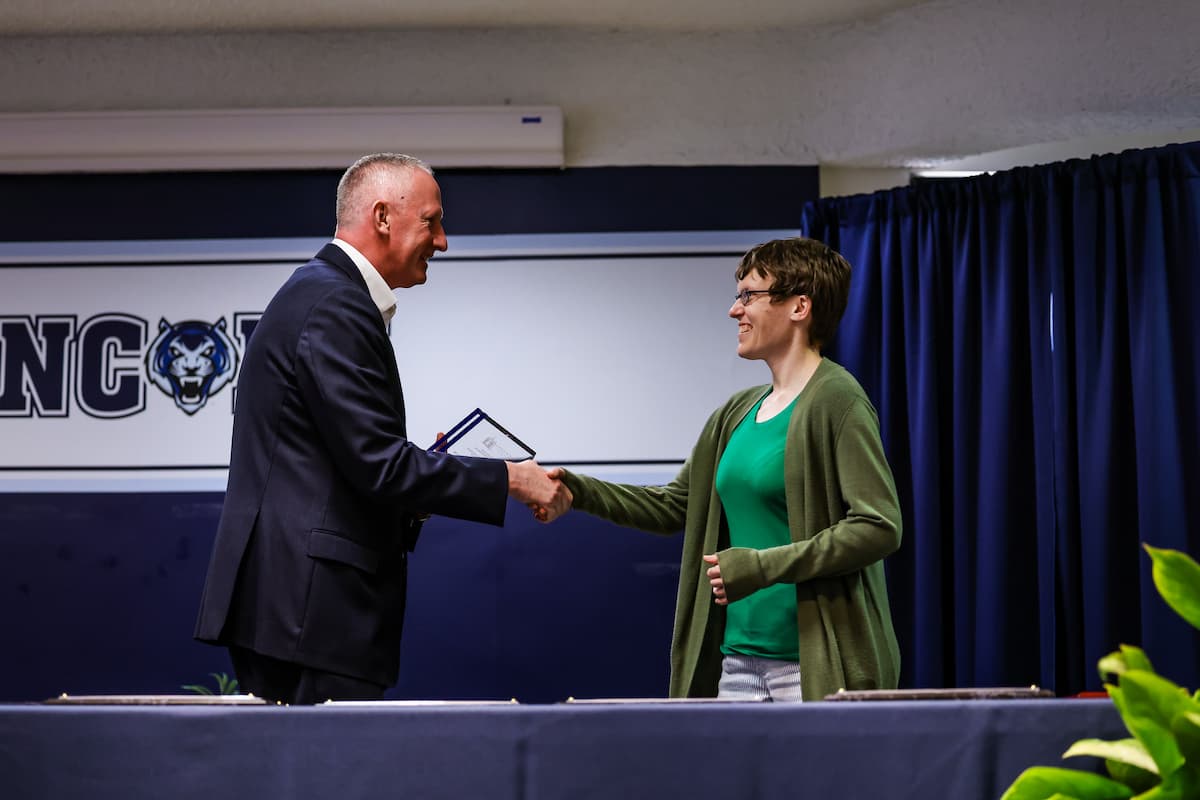 President Moseley shakes the hand of Elizabeth Dorssom.