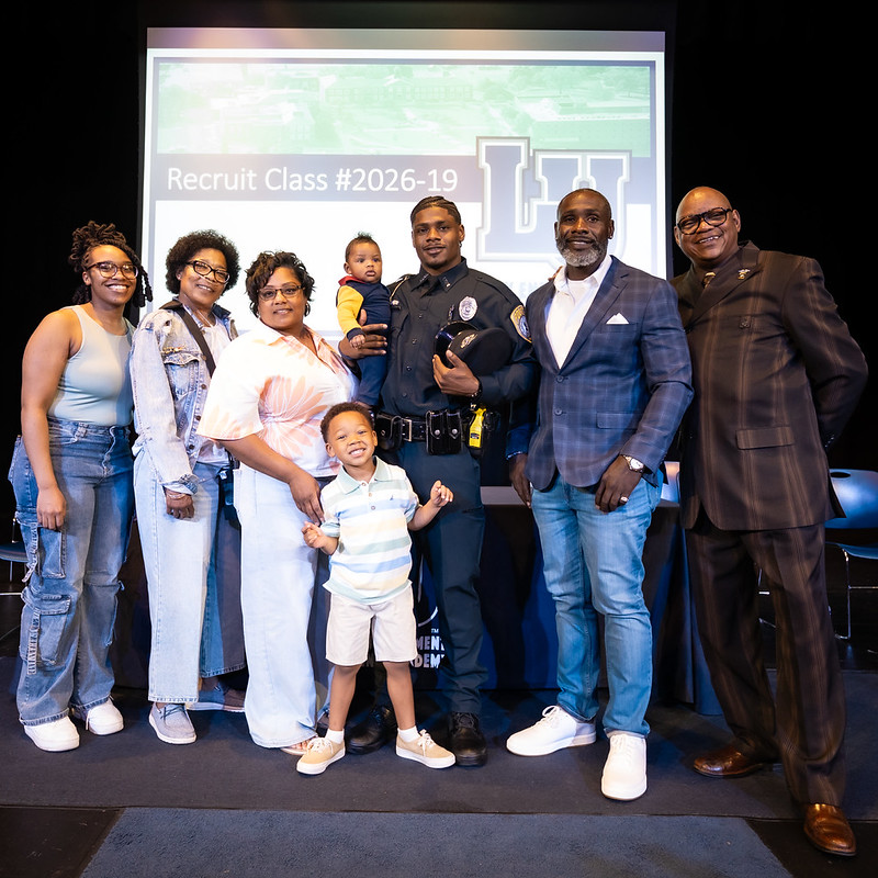 Graduate of the Lincoln University Law Enforcement Training Academy Recruit Class #2026-19 poses with family and academy leaders.