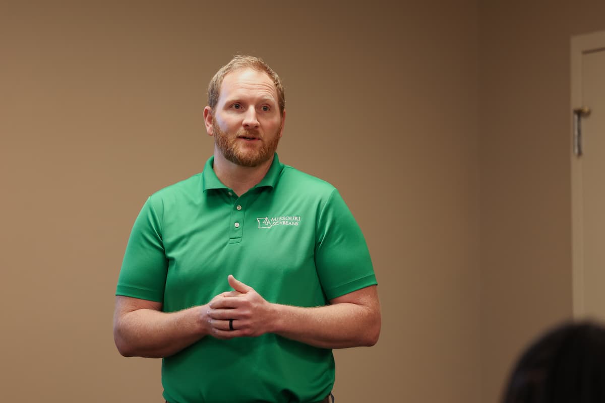 Matt Amick speaks to attendees during a field day presentation in Dexter, Missouri, wearing a green Missouri Soybeans polo shirt.